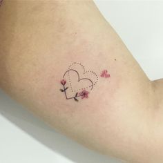 a woman's arm with two hearts and flowers on the left side of her arm