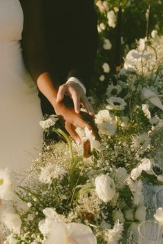 the bride and groom are cutting their wedding bouquets with flowers in front of them