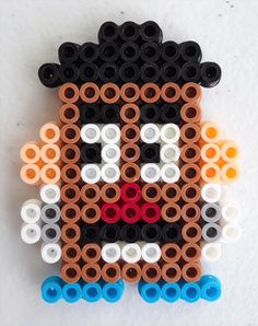 a piece of art made out of legos on a white surface with black and orange circles around it