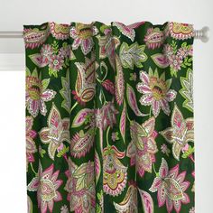 a green and pink floral curtain hanging from a window