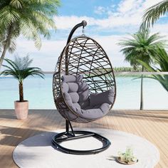 a hanging egg chair on a deck with palm trees