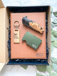 a box with three different items in it, including a keychain and knife