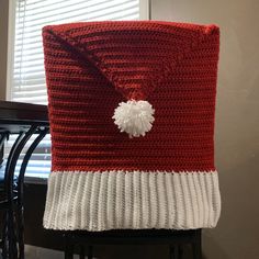 a red and white crocheted blanket sitting on top of a chair