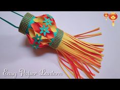 an orange and yellow tassel on a white surface with the words easy paper lantern