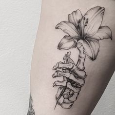 a black and white photo of a flower on the thigh with bones attached to it