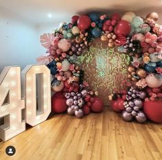 the number forty is displayed in front of balloons and flowers on display at an event