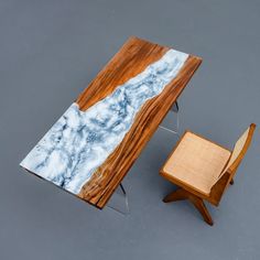 a table and chair made out of wood with marble on the top, sitting next to each other