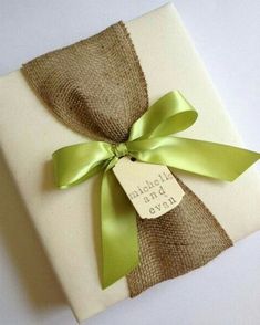 a gift wrapped in burlap with a green ribbon