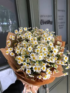 a bouquet of daisies in front of a door