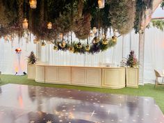 a stage set up for a wedding with stars on the floor and lights hanging from the ceiling