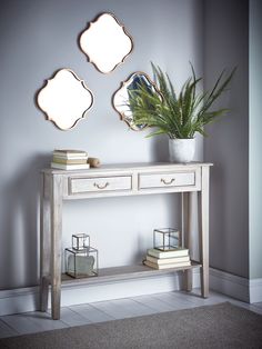 a white console table with three mirrors above it