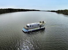 a large boat floating on top of a lake next to trees in the middle of the ocean