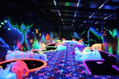 a brightly lit room filled with lots of fake snow sculptures and colorful lights on the walls