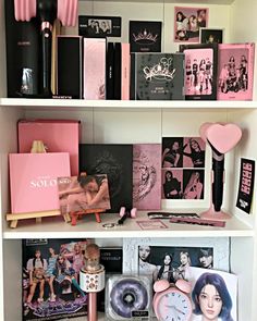 the shelves are filled with pink and black items, such as books, pictures, and photos