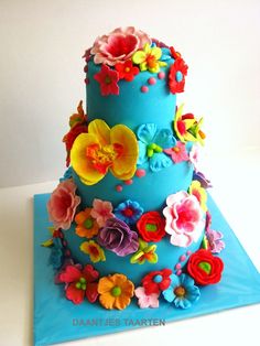 a three tiered blue cake with flowers on it