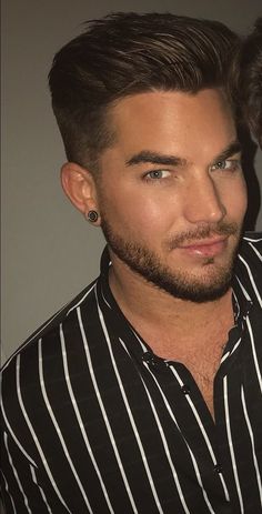 a man with a beard wearing a black and white striped shirt