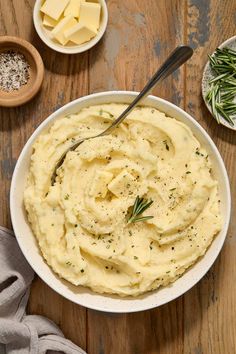 a bowl of mashed potatoes with butter and herbs