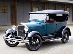 an old fashioned car parked in front of a building