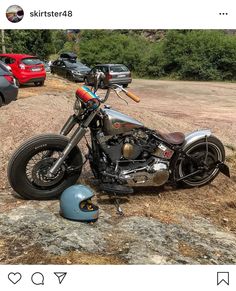 a motorcycle parked on the side of a dirt road next to a pile of junk