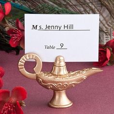 a place card holder on a table with red flowers