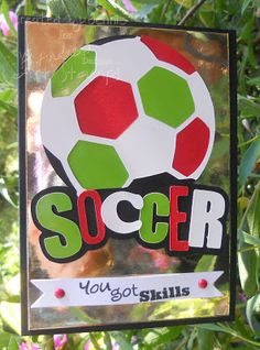 a soccer sign hanging from the side of a tree with flowers in the back ground