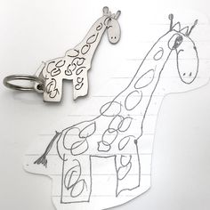 a drawing of a giraffe and a keychain on a piece of paper