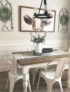 a dining room table with two chairs and a potted plant on top of it