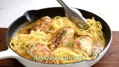 a pan filled with chicken and noodles on top of a wooden table