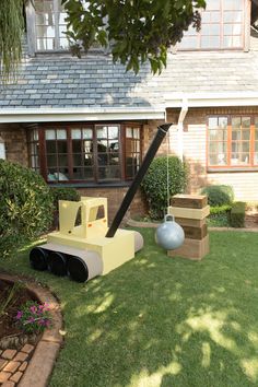 a yellow and black toy bulldozer sitting in the grass