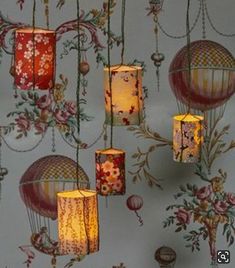 lanterns hanging from the ceiling in a room with floral wallpaper and flowers on it