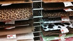 the shelves are full of different fabrics for sale at the store, including leopard and zebra prints