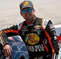 a man with sunglasses on standing next to a car