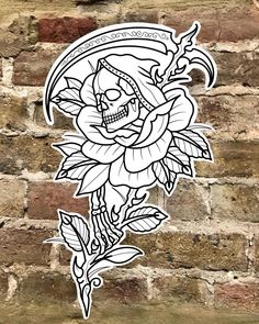 a sticker with a skull and flower on it's side against a brick wall