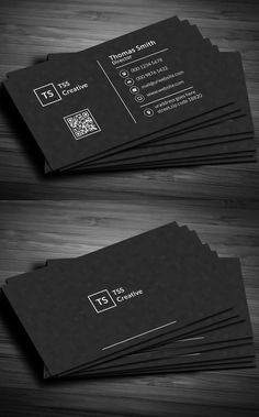 two black business cards on top of a wooden table, with the same size and color