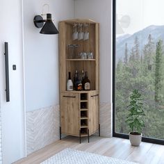 a wooden cabinet with wine glasses and bottles on it in front of a large window