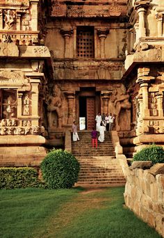 some people are walking up and down the stairs to an old building with carvings on it