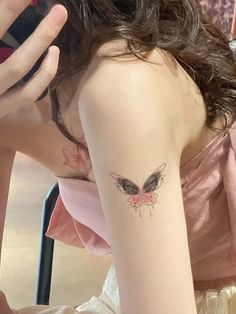 a woman with a butterfly tattoo on her arm