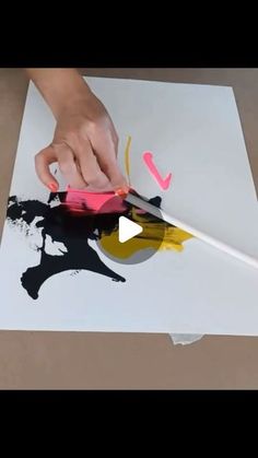 someone is using scissors to cut out the design on a piece of paper with paint