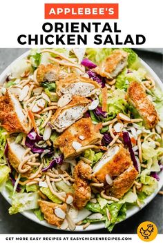 a salad with chicken, lettuce and almonds in a white bowl on a gray surface