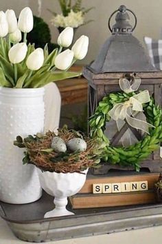 a tray topped with white flowers next to a bird's nest filled with eggs