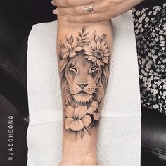 a woman's arm with a lion and flowers on it