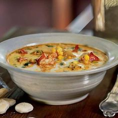 a white bowl filled with soup sitting on top of a wooden table