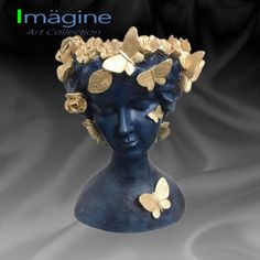 a blue statue with gold butterflies on it's head and the words imagine art collection