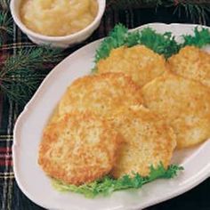 three crab cakes on a white plate with lettuce and sauce in the background