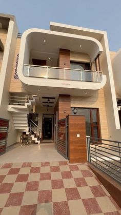 the entrance to a modern house with checkered tile flooring and stairs leading up to it