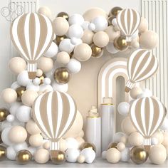 balloons and other decorations are arranged in the shape of a house with gold, white and silver accents