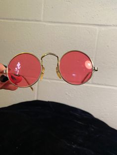 "These sunnies are a safe way to see the world through rose-colored lenses! Perfect fit for a woman or smaller man. Due to age, they have a few flaws: the arms are a bit bent out of shape, but this doesn't have much impact on the wear. The lenses are also mostly scratched, but again, this has no little to no effect on the wear. Great for photoshoots or collecting True vintage, not a reproduction Each lens measures 1 7/8\" in diameter." Pink Sunglasses With Mirrored Lenses And Round Frame, Pink Round Frame Sunglasses With Mirrored Lenses, Vintage Round Sunglasses With Uv Protection, Vintage Round Sunglasses With Polarized Lenses, Vintage Red Sunglasses With Mirrored Lenses, Vintage Sunglasses With Mirrored Glass Lenses, Vintage Round Sunglasses With Mirrored Lenses, Vintage Pink Sunglasses For Party, Vintage Pink Sunglasses For Summer