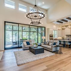 a living room filled with furniture and a chandelier hanging over the top of it