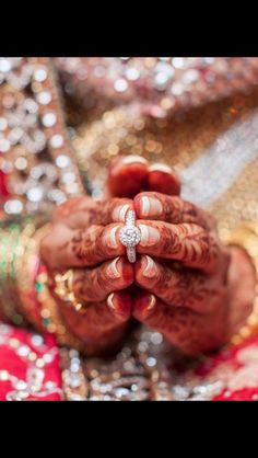 the bride is holding her wedding ring in her hands and she has both hands together