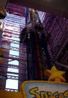 an amusement park ride with the name space shuttle on it's sign and yellow stars